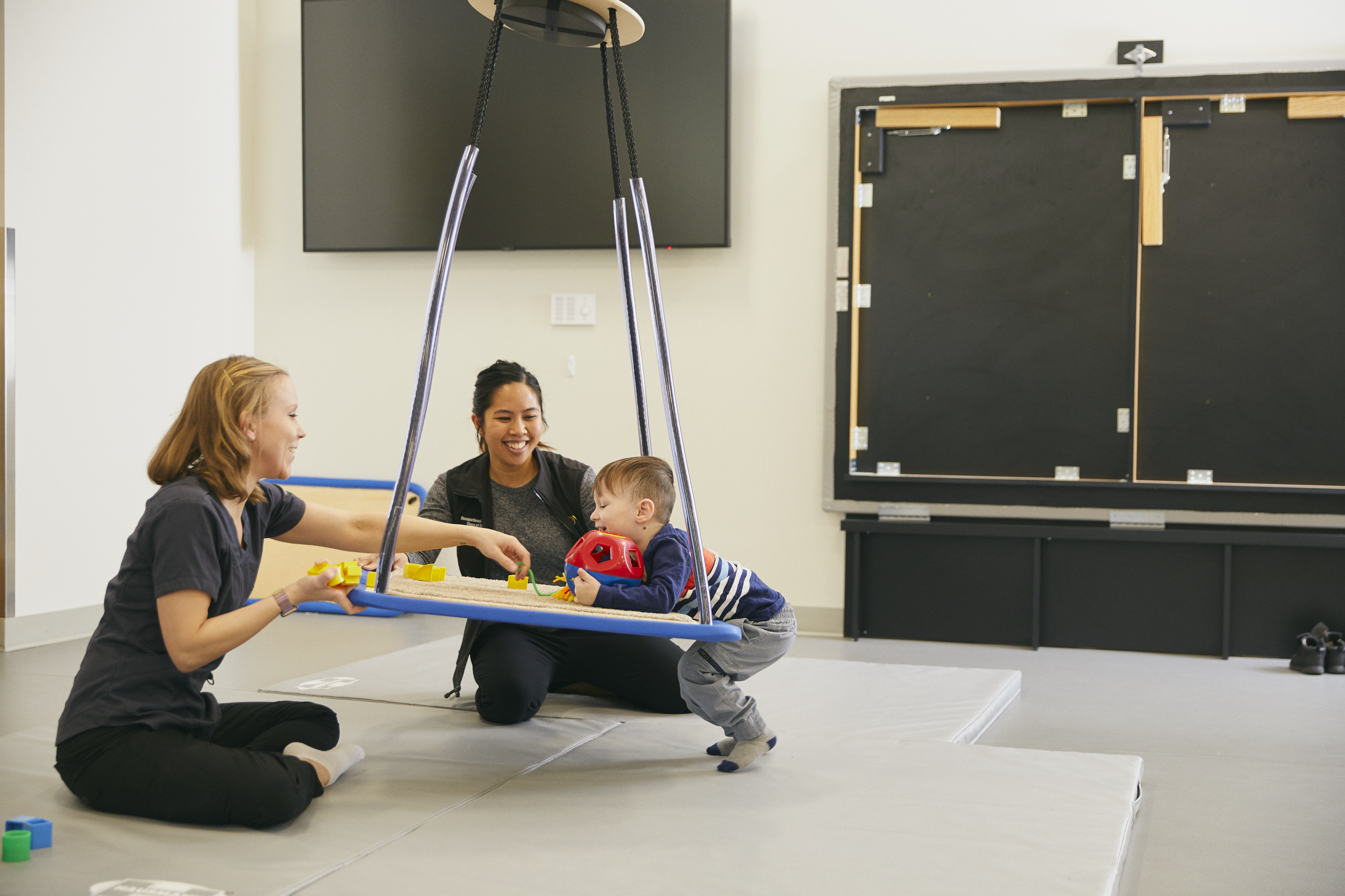 Occupational Therapists working with a baby in a bounce chair